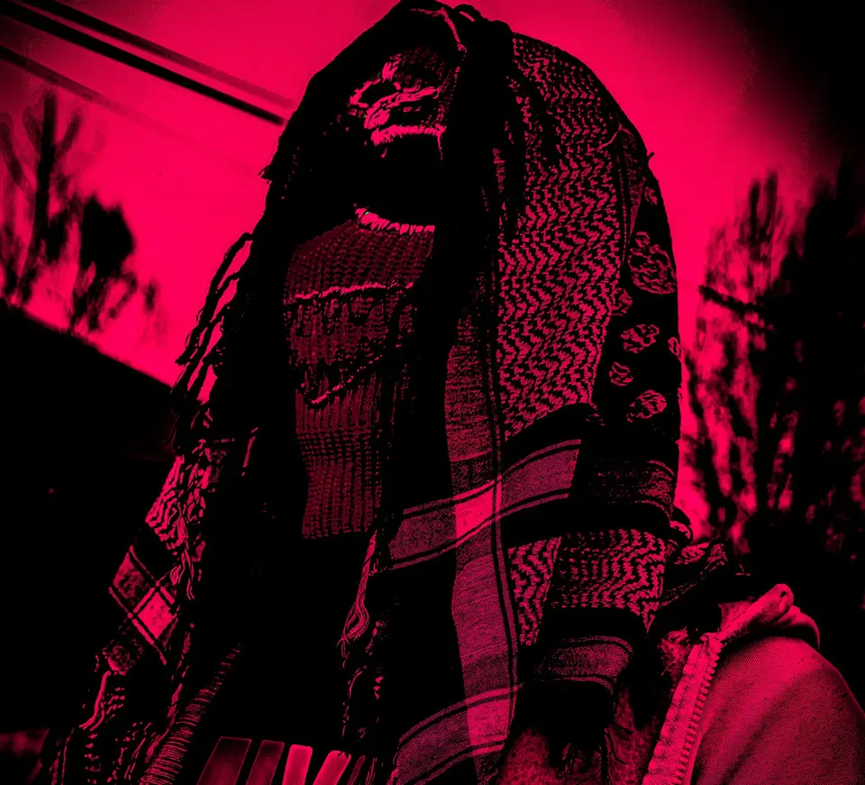 Silhouette unter einer Kufiya mit einer bestickten Sturmhaube, rosa Licht
